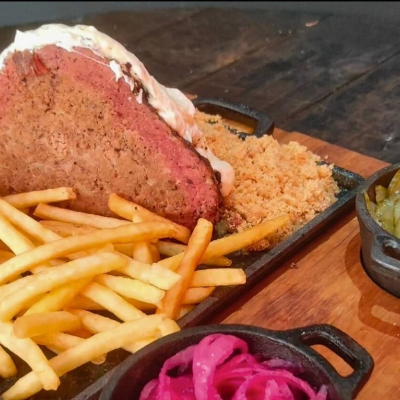 Cupim grill defumado por 5 horas na lenha frutífera, coberto com cream cheese cremoso e mussarela derretida. Acompanhado de fritas douradas, picles de pepino, picles de cebola roxa e farofa crocante de bacon.