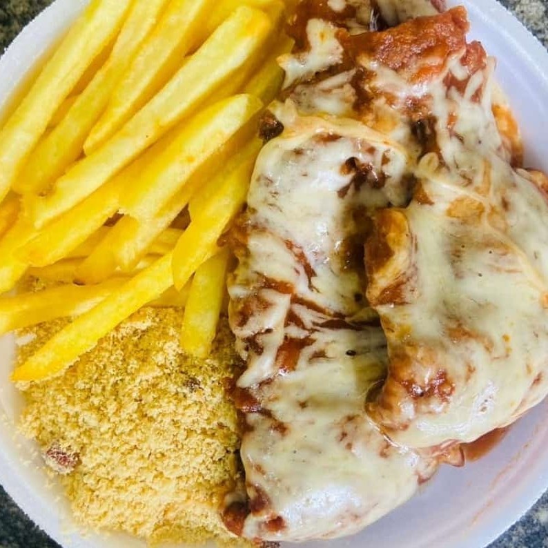 Bife de alcatra (sem nervos e sem gordura) à milanesa, coberto por uma camada de queijo, banhado por molho de tomate caseiro e uma pitada de orégano na finalização. - Campeão de vendas em nosso delivery. Acompanha arroz, feijão e farofa. Escolha entre: purê, macarronese, salada ou fritas.  Obs.: - Embalagem Pt102. - Ideal para 1 pessoa. Esperamos que você tenha uma ótima refeição!  Tag: Parmegiana de carne, bife à parmegiana.