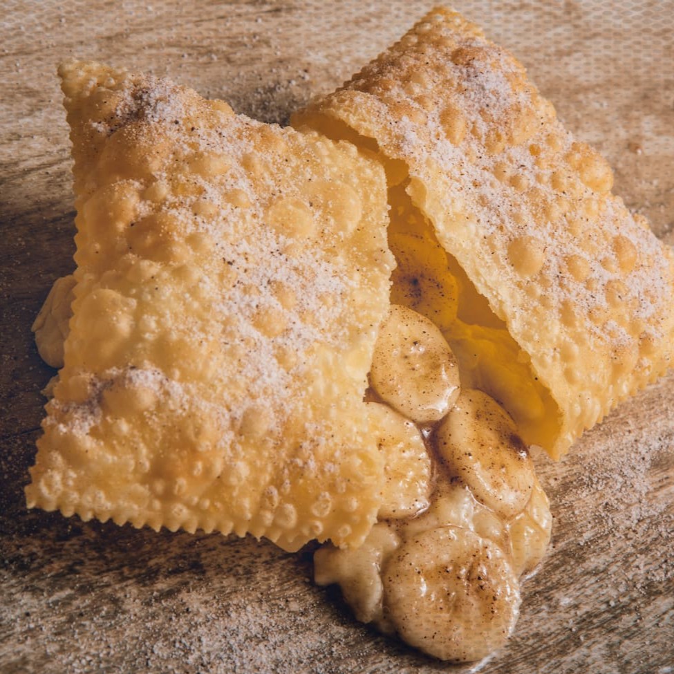 Deliciosa massa crocante polvilhada com açúcar e canela recheado de banana e canela. Sugestão: Nosso pastel de banana combina perfeitamente com a borda de chocolate, experimente essa combinação e nos conte o que achou! Tamanho 14 X 9,5 Cm