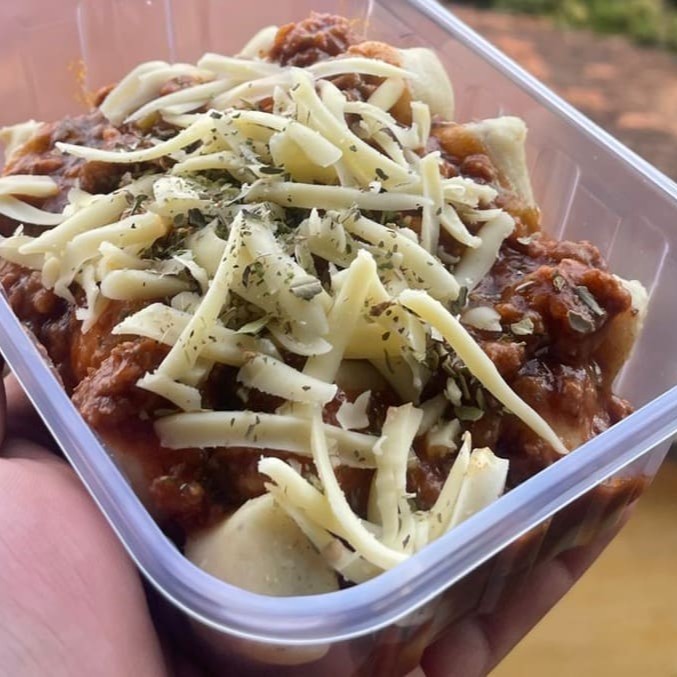 Nhoque caseiro macio e saboroso, coberto com molho à bolonhesa bem temperado e finalizado com uma generosa camada de queijo derretido. Uma combinação clássica e irresistível que conquista em cada garfada!
