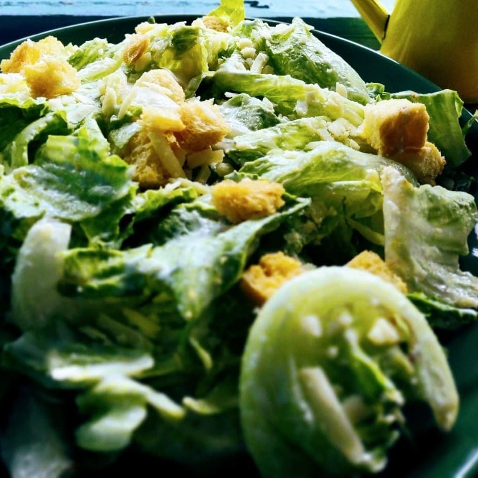 Alface, croutons parmesão e molho ceasar.