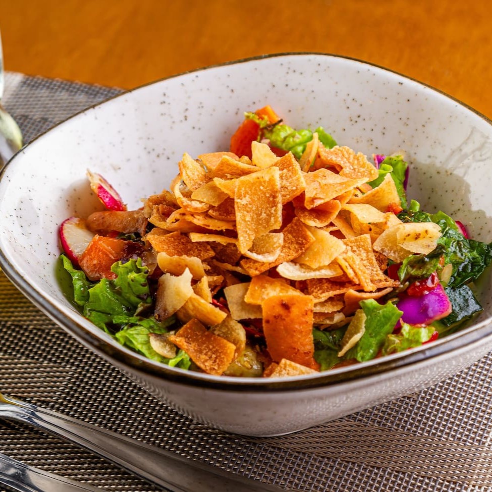 Alface, tomate, pepino, cenoura, rabanete, pedaços de pão frito, cebola e hortelã com melaço de romã