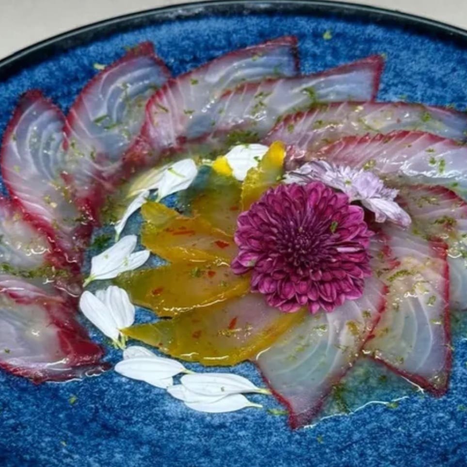 Desfrute da sofisticação e sabor inconfundível do nosso Carpaccio de Gravilax! São 20 lâminas finíssimas de peixe curado com especiarias, delicadamente temperadas e preparadas para realçar o sabor profundo e único da cura. O gravilax, um peixe fresco e macio, recebe o toque especial das especiarias, oferecendo uma experiência gustativa refinada e deliciosa. Perfeito para quem aprecia pratos leves,