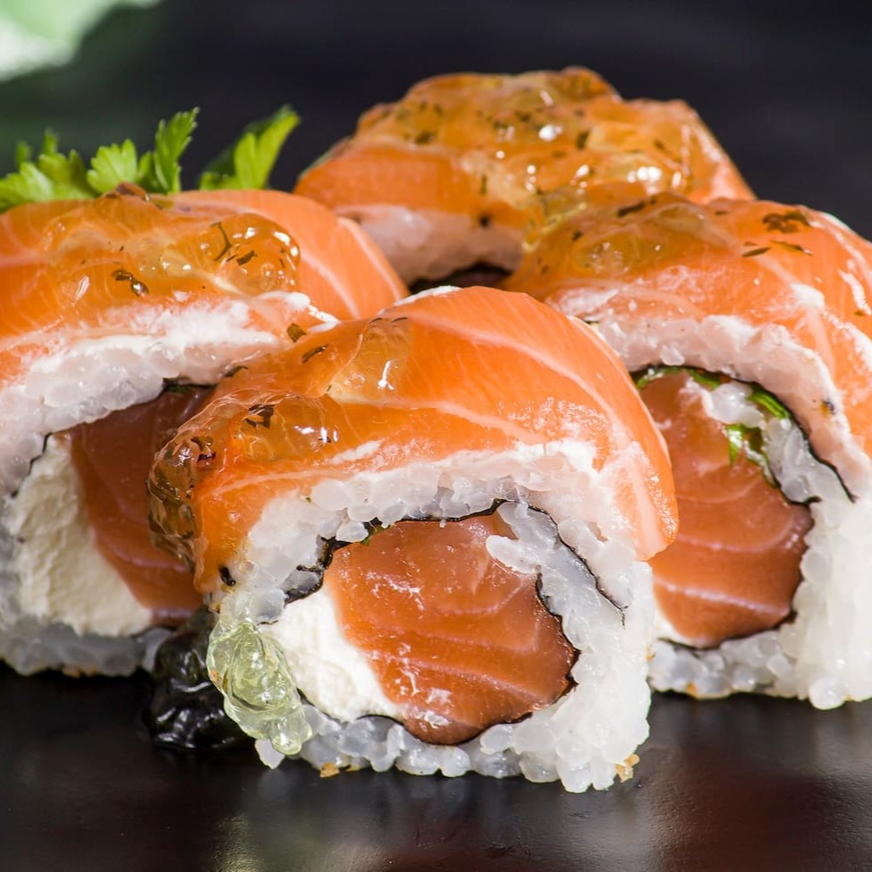 Uramaki philadelfia com lâminas de salmão por cima finalizado com geléia de hortelã.