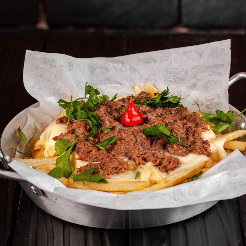 Batata Palito Coated Crispy, coberta com generosas camadas de Catupiry cremoso, que derrete suavemente ao toque. A costela bovina, cuidadosamente desfiada com molho barbecue, adiciona uma textura rica e um sabor intenso que contrasta perfeitamente com a suavidade do Catupiry.