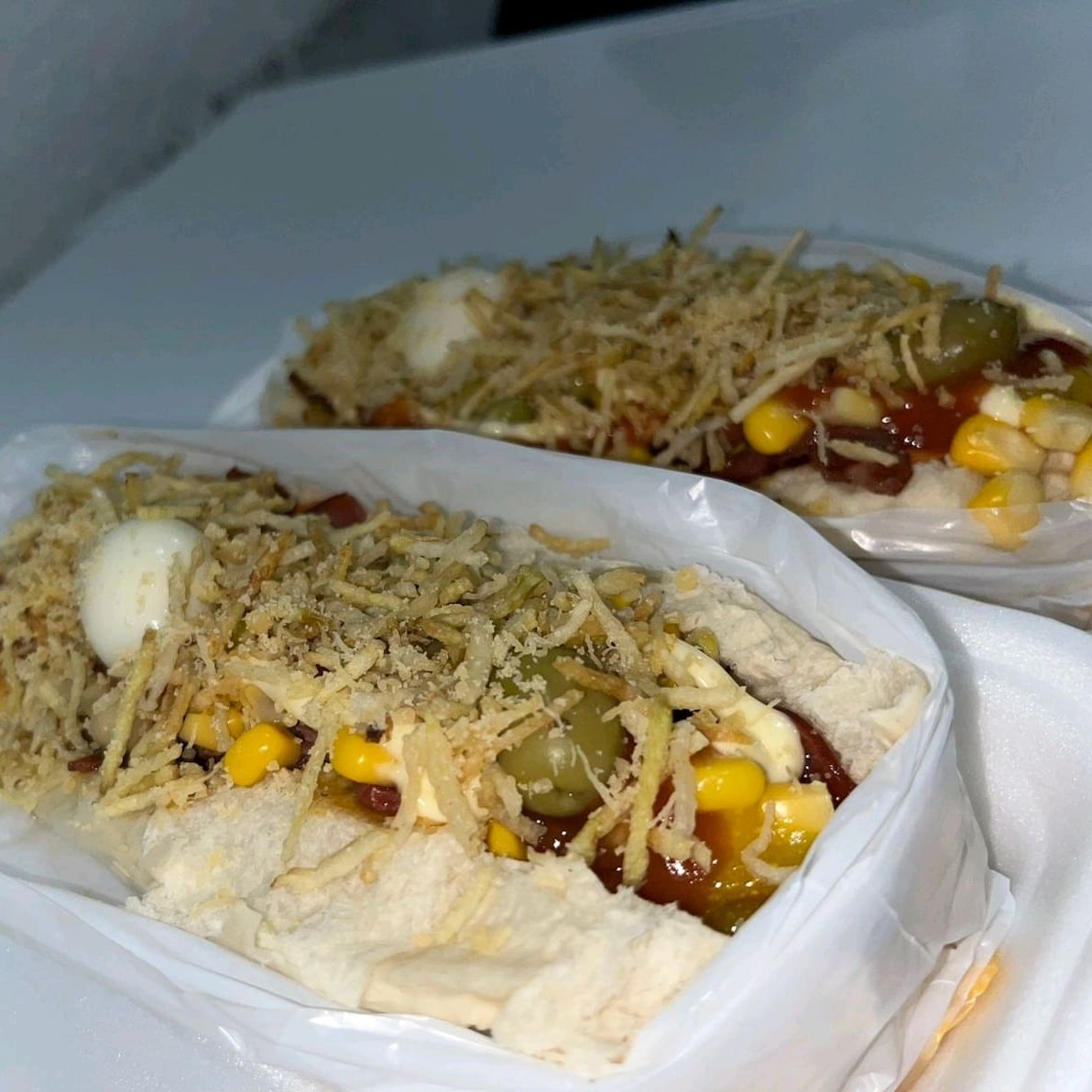 Milho, ervilha, passas, azeitona, ovo de codorna, mostarda, ketchup, maionese, queijo ralado, cenoura, calabresa, bacon e batata palha