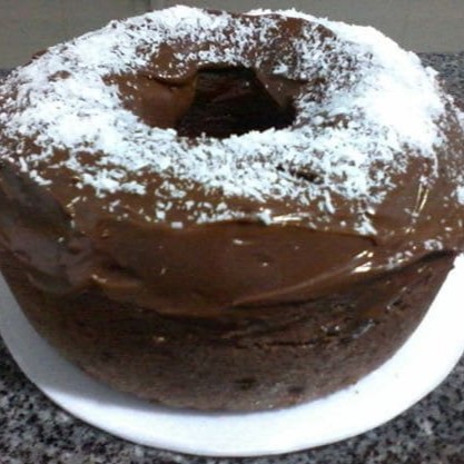 Bolo de chocolate com cobertura de brigadeiro e coco, artesanal, com sabor marcante e tropical.