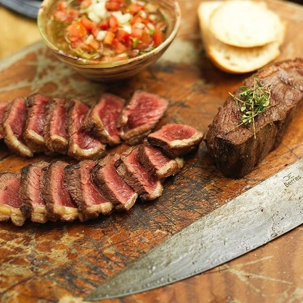 Delicie-se com o sabor inconfundível da picanha, um dos cortes mais apreciados da carne bovina. Nossos cortes de picanha são preparados com maestria, garantindo uma crosta suculenta e um interior tenro, perfeitamente temperado para realçar o seu sabor natural. Para acompanhar esta maravilha da culinária, oferecemos três acompanhamentos à sua escolha.