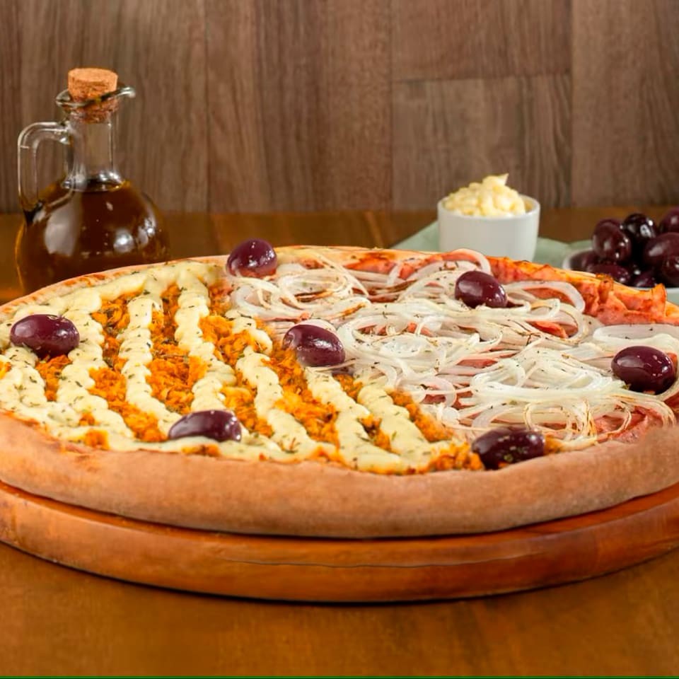 Pizza grande 1/2 Frango com Catupiry 1/2 Calabresa (8 fatias): metade com frango desfiado, Catupiry cremoso e mussarela; a outra metade com calabresa fatiada, cebola, mussarela derretida e orégano.