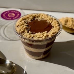 Brigadeiro de chocolate ao leite cremoso com camadas de farofa de biscoitos! A famosa palha italiana na versão de colher. A Cake Shot não altera e/ou adiciona ingredientes aos produtos já formulados. - 230g Copo da felicidade - bombom no copo