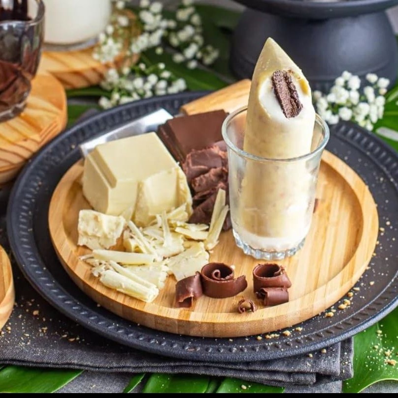 O 'Sacolé Tablito' da linha 'Sacolé Gourmet Gold' é um verdadeiro deleite para o paladar. Trata-se de um sorvete de baunilha extremamente cremoso e envolvente, com um palito de chocolate ao leite como recheio. A experiência culmina com uma irresistível casquinha de chocolate branco, aperfeiçoada com uma farofa de amendoim que adiciona textura e sabor. Este prato remete a um famoso sorvete que certamente despertará memórias nostálgicas. Prepare-se para se apaixonar por esta sobremesa gourmet.