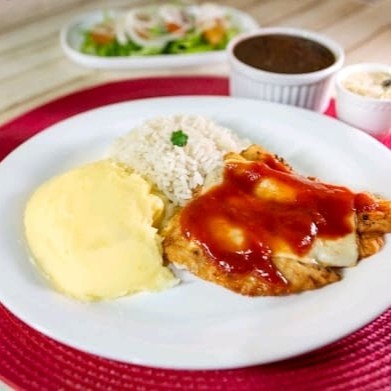 Um prato sofisticado e delicioso, com filé de peixe empanado e coberto com queijo derretido e molho de tomate caseiro. Acompanha arroz soltinho, feijão saboroso, farofa crocante com calabresa (em embalagem separada) e mais um acompanhamento que desejar.  Nossas refeições são servidas em embalagem de isopor de aproximadamente 700ml.