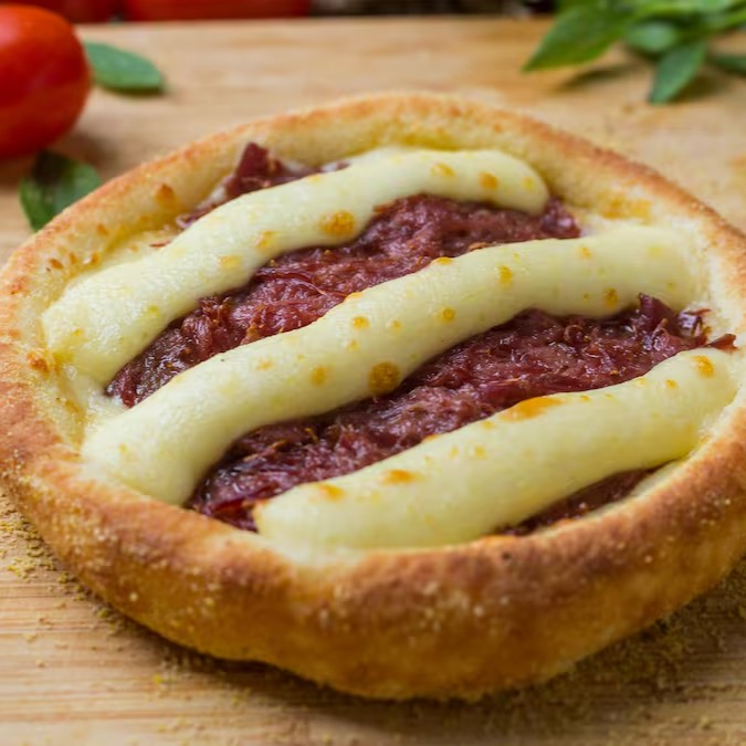 Esfiha de Carne Seca (Grande): Recheada com mussarela, carne seca e Catupiry. Sabor marcante e cremoso em cada mordida!