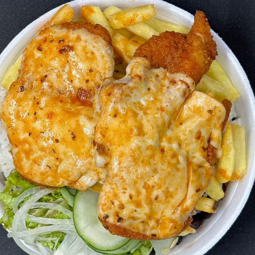 Frango à Parmegiana com Fritas: uma deliciosa combinação de sabores autênticos. O frango, suculento e crocante, é empanado e coberto com um molho de tomate caseiro e queijo parmesão derretido, criando uma camada irresistível de sabor. Acompanha batatas fritas crocantes, arroz branco soltinho e feijão fresco, que acrescentam uma nota de conforto a este prato. Para completar, uma refrescante salada de folhas frescas. Um prato cheio de tradição, perfeito para aqueles que apreciam a autêntica cozinha caseira.