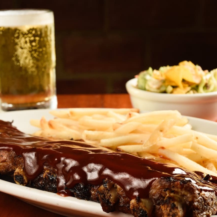 Nossa costela especial regada ao barbecue, servida com batata frita e salada coleslaw.