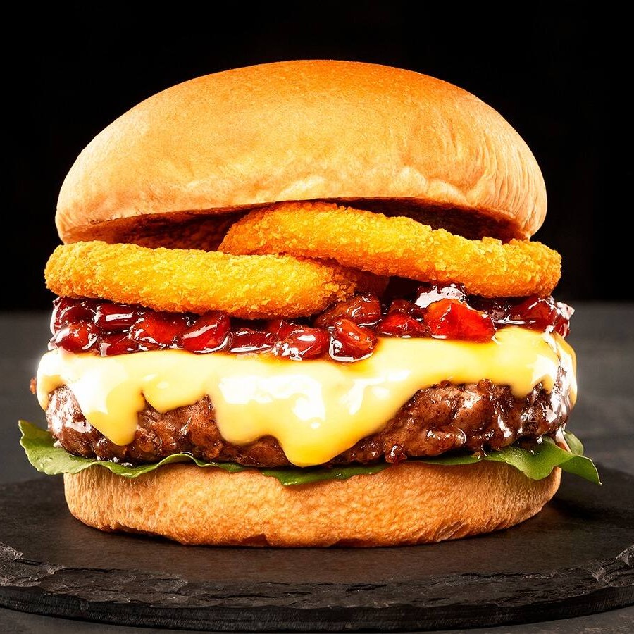 Pão, Blend de 160g, Queijo Mussarela, Geleia de bacon, Rúcula e Onion Rings.