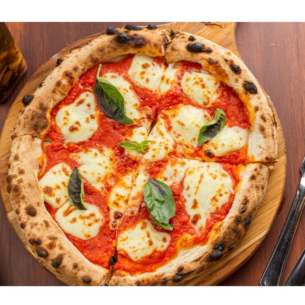 Massa em fermentação natural, molho de tomate, mozzarela de búfala e manjericão