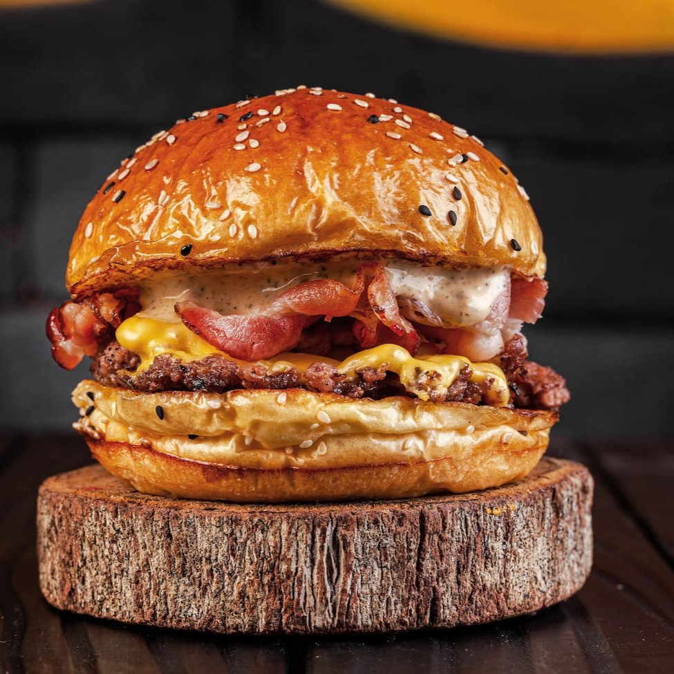 Composto por um pão Brioche fresquinho e macio, que leva um smash de 80g. Acrescentamos uma generosa fatia de queijo americano, derretido e aconchegante. O bacon fatiado, crocante e saboroso, adiciona uma nota de ousadia. Para finalizar, uma generosa camada de nossa exclusiva maionese de chimichurri defumado, que dá ao prato um toque especial, repleto de sabor e personalidade.