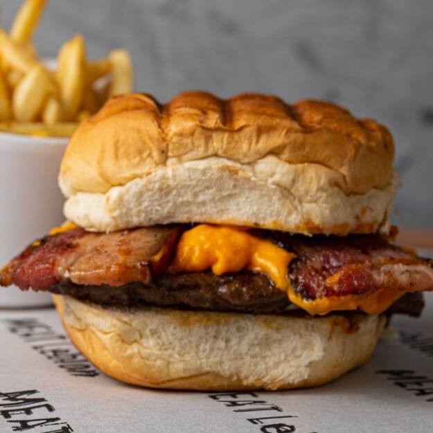 O nosso delicioso Sanduíche com Hambúrguer de Costela Angus (150gr), Generosas fatias de Bacon, Queijo Cheddar, Molho Bbq, Maionese, Cebola Caramelizada.