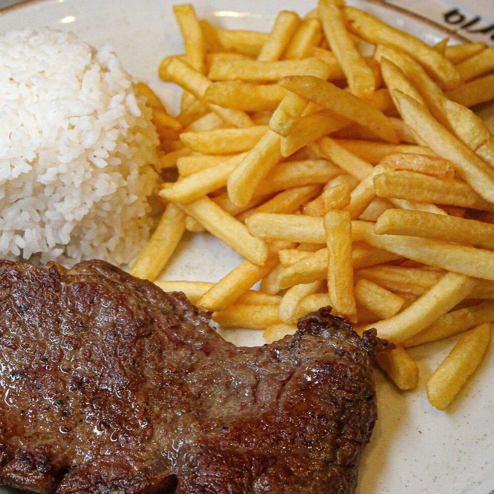 Corte suculento de contra filé grelhado no ponto ideal, acompanhado de batata frita crocante, arroz branco soltinho e feijão cremoso. Uma refeição completa, saborosa e cheia de energia para o seu Dia!