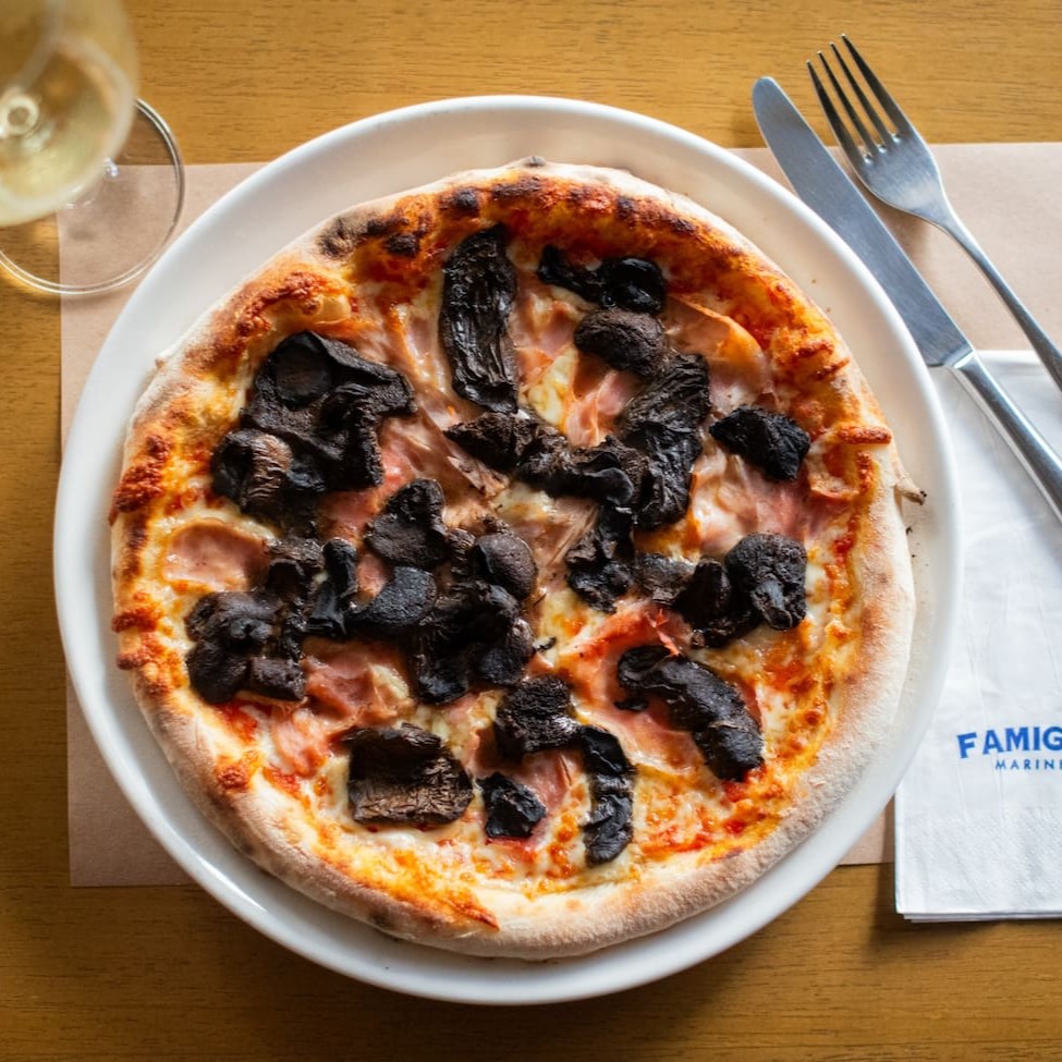 Delicie-se com nossa pizza artesanal, coberta com molho de tomate pelati, muçarela de búfala cremosa, cogumelos funghi e presunto royale. A combinação perfeita de ingredientes de alta qualidade para uma experiência saborosa e sofisticada.