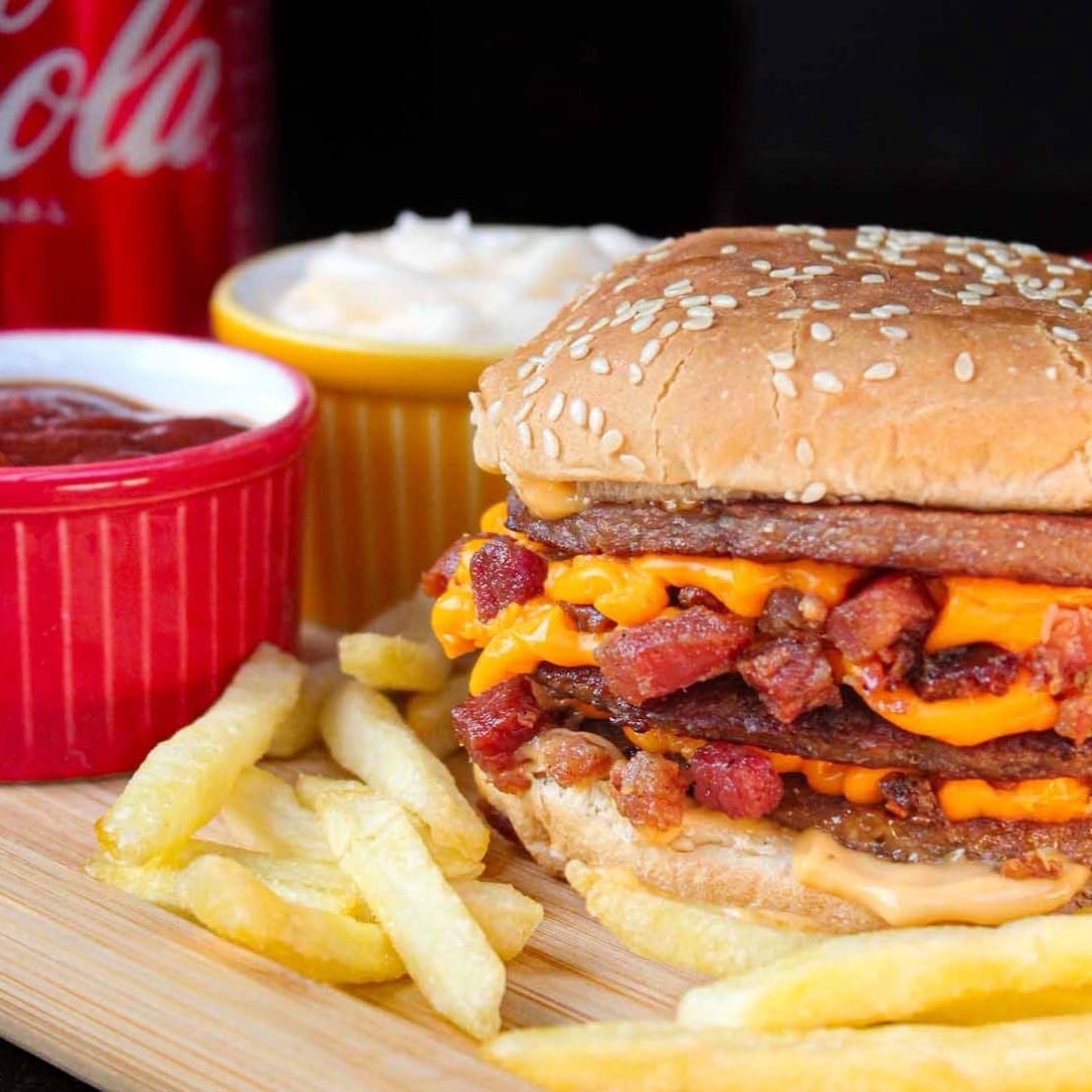 Pão com gergelim, Três carnes, bastante cheddar e bacon, molho  + coca e batata frita