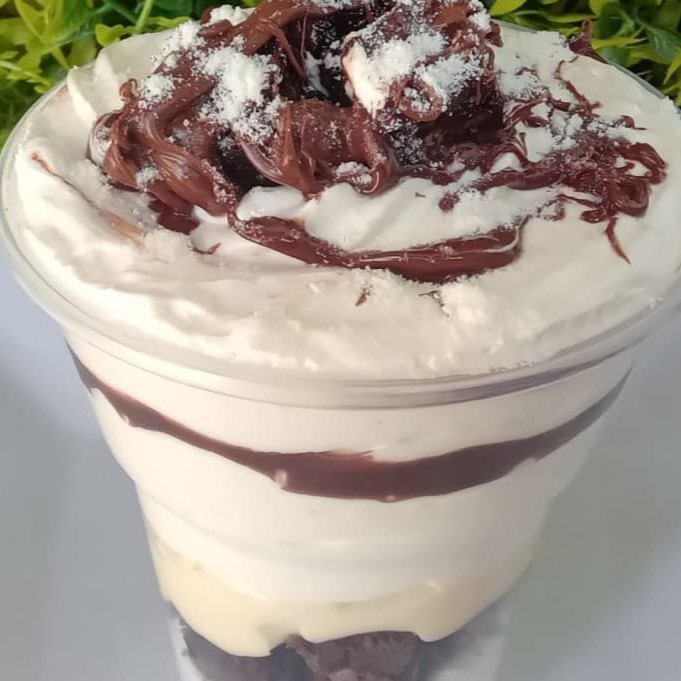 Desfrute do nosso luxuoso 'Copo da Felicidade Leite Ninho com Nutella'. Esta obra-prima culinária é composta por uma mousse divinamente cremosa de Leite Ninho, harmonizada com pedaços robustos de brownie, macios e ricamente chocolateados. Adicionamos uma dose de recheio de Leite Ninho, criando uma sinfonia doce e equilibrada. Para os devotos de Nutella, oferecemos uma camada generosa deste creme de avelã irresistível. Finalizamos com pedaços de brownie e Nutella, criando um palco de texturas e sabores cativantes. Este prato é a verdadeira encarnação da felicidade, um deleite que vale cada colherada!