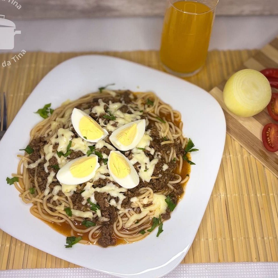 Nosso Macarrão á Bolonhesa acompanha molho de tomate caseiro com carne moída meticulosamente temperada, finalizado com um generoso toque de queijo derretido e um ovo cuidadosamente cozido