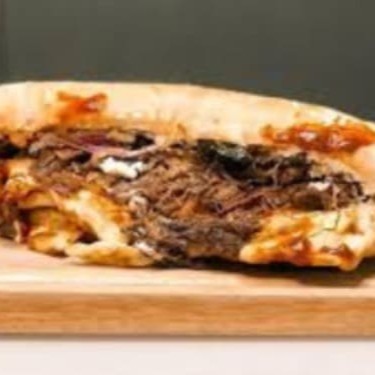 Sanduiche de costela bovina no bafo, desfiada, no pão ciabatta com queijo mussarela.