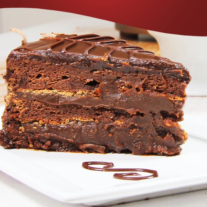 Massa leve de cacau recheada e coberta com brigadeiros e confeitada com ganache e raspas de chocolate.