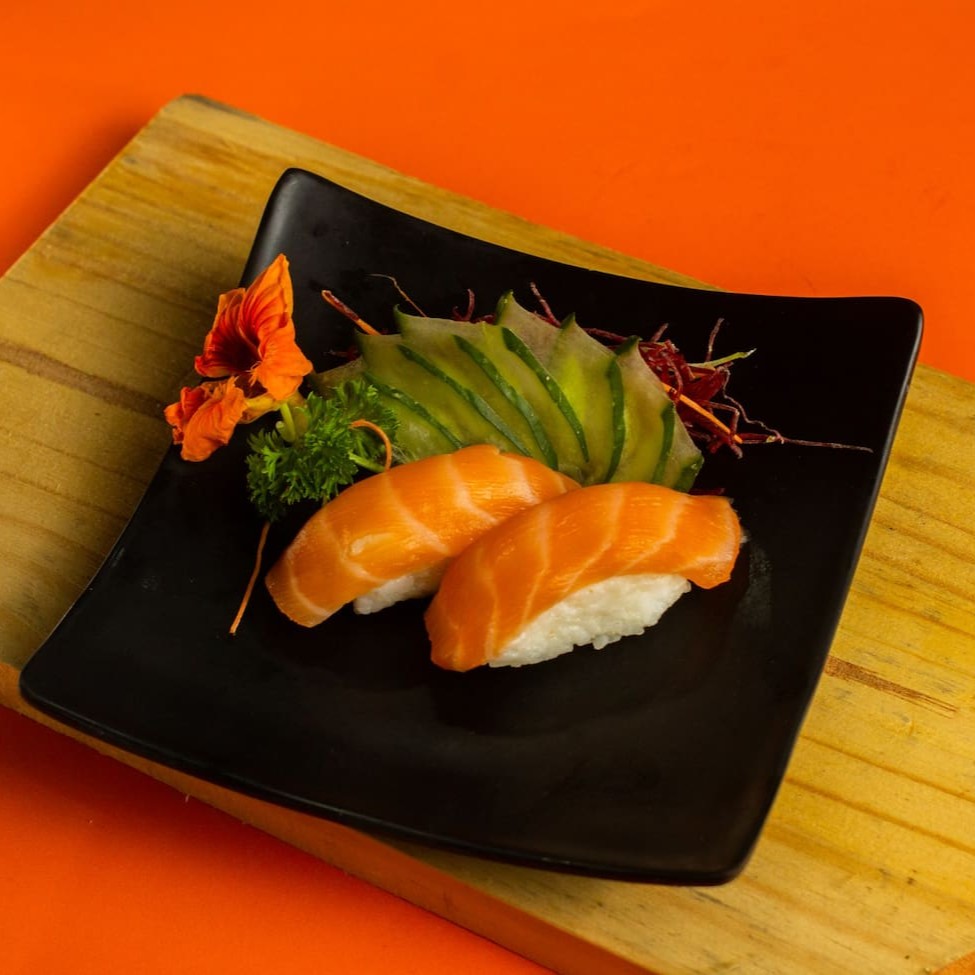 """Porção com 4 unidades de sushi de salmão fresco, cuidadosamente preparadas com arroz temperado e fatias generosas de salmão selecionado. Cada peça oferece equilíbrio perfeito entre textura e sabor, trazendo a suavidade do peixe combinada com a leveza do arroz, ideal para quem aprecia o melhor da culinária japonesa em uma porção prática e deliciosa."""
