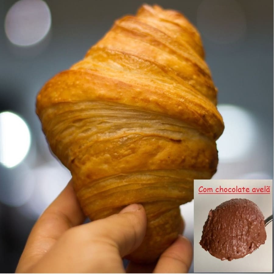 Croissant Simples (aprox 85g), acompanha 40g de pasta de chocolate com avelã (contém adoçante). *Ingredientes: farinha de trigo orgânica, óleo de coco, óleo de girassol, gordura de palma, manteiga de cacau, água, lecitina de soja, sal, ácido lático, lievito madre (fermento natural), açúcar demerara orgânico e fermento biológico seco. #Contém: soja e trigo/glúten.