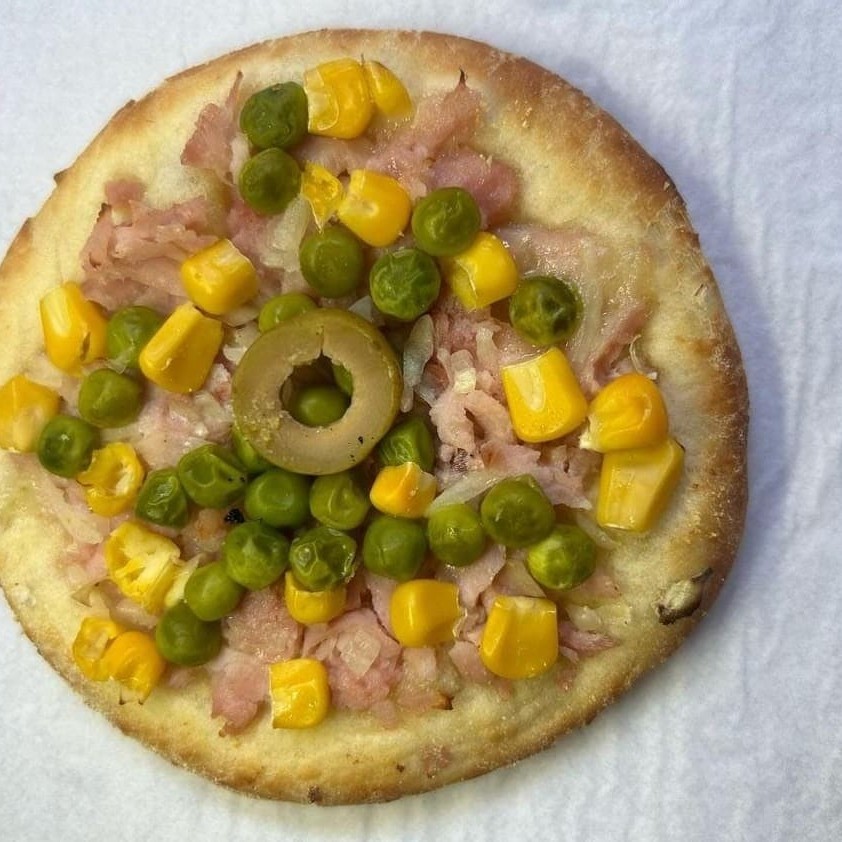 Deliciosa esfiha aberta feita com massa artesanal, sabor portuguesa (mussarela, presunto, ovos, cebola, pimentão, ervilha, milho e azeitona)