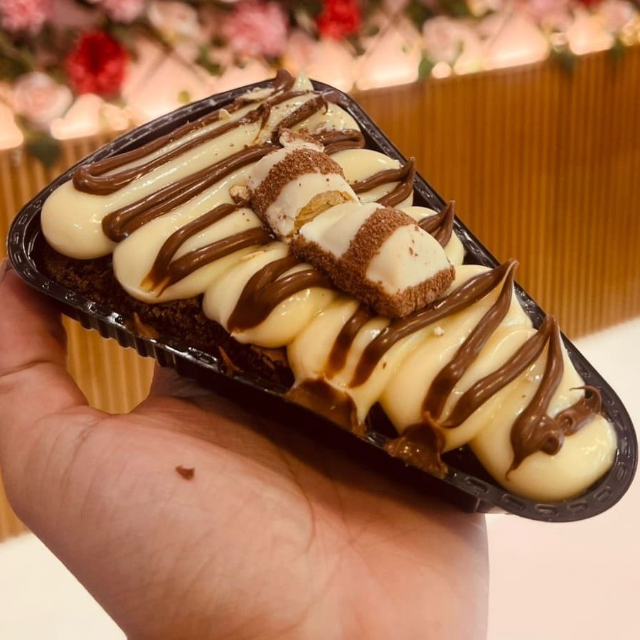 Brownie bem úmido e chocolatudo em formato de fatia (pizza), finalizado com brigadeiro de Ninho, fios de Nutella, e Kinder; uma tentação, perfeito para matar sua vontade de um docinho.
