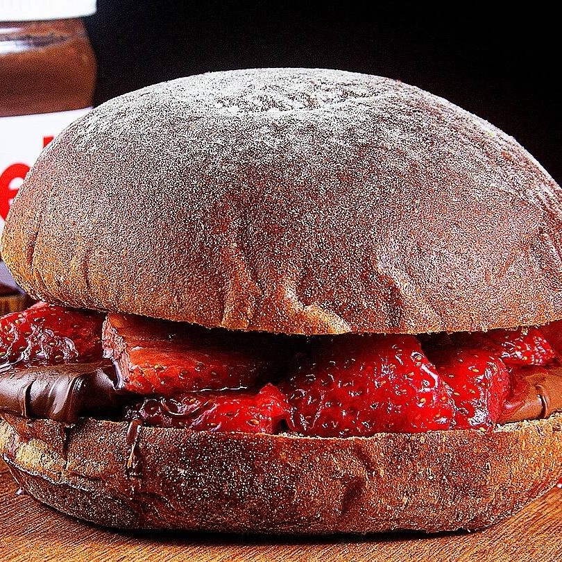 Quem não gosta de Nutella? Nós amamos!  Esse sanduíche de Nutella é espetacular! Pão de chocolate selado na manteiga, que dá uma crocância, 100g de Nutella, morango, calda de morango e castanha. E pode adicionar Chantilly também! Basta adicionar em complementos. Está uma delicia, não deixe de pedir.