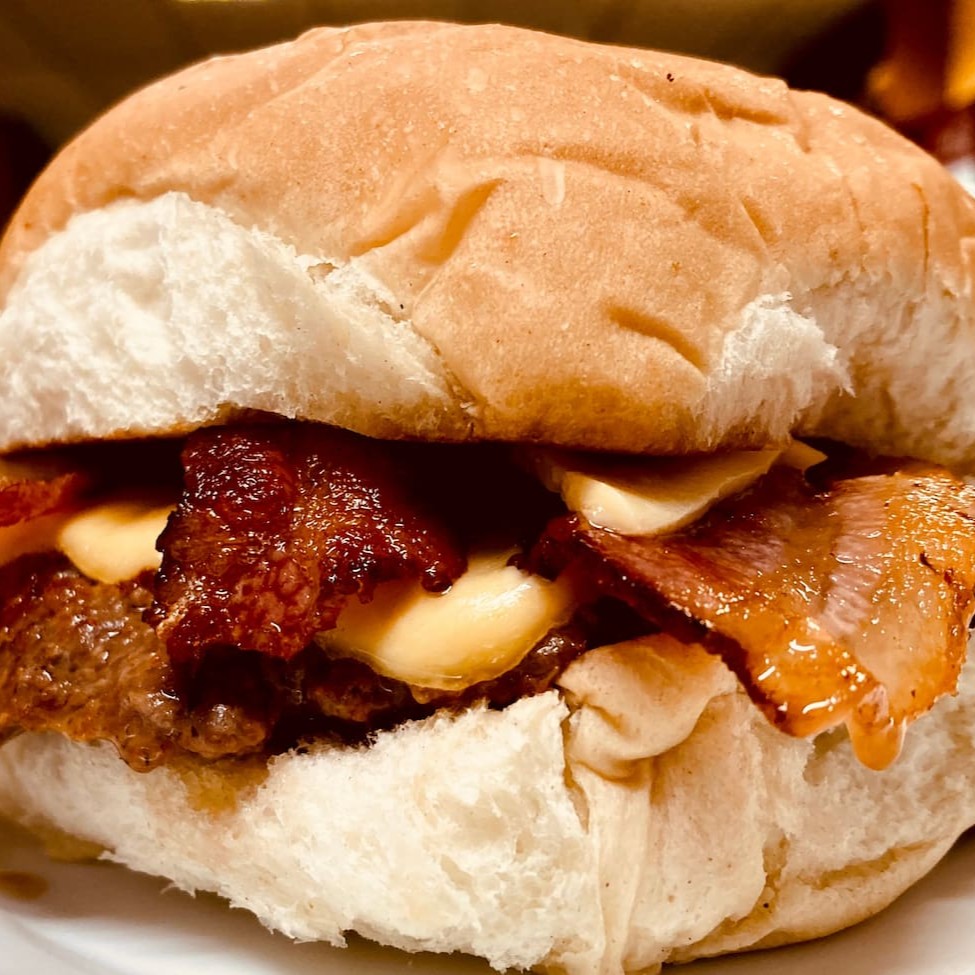 Hamburger tradicional da casa (130g), generosa fatia de queijo prato e tiras suculentas de bacon (o mais vendido)