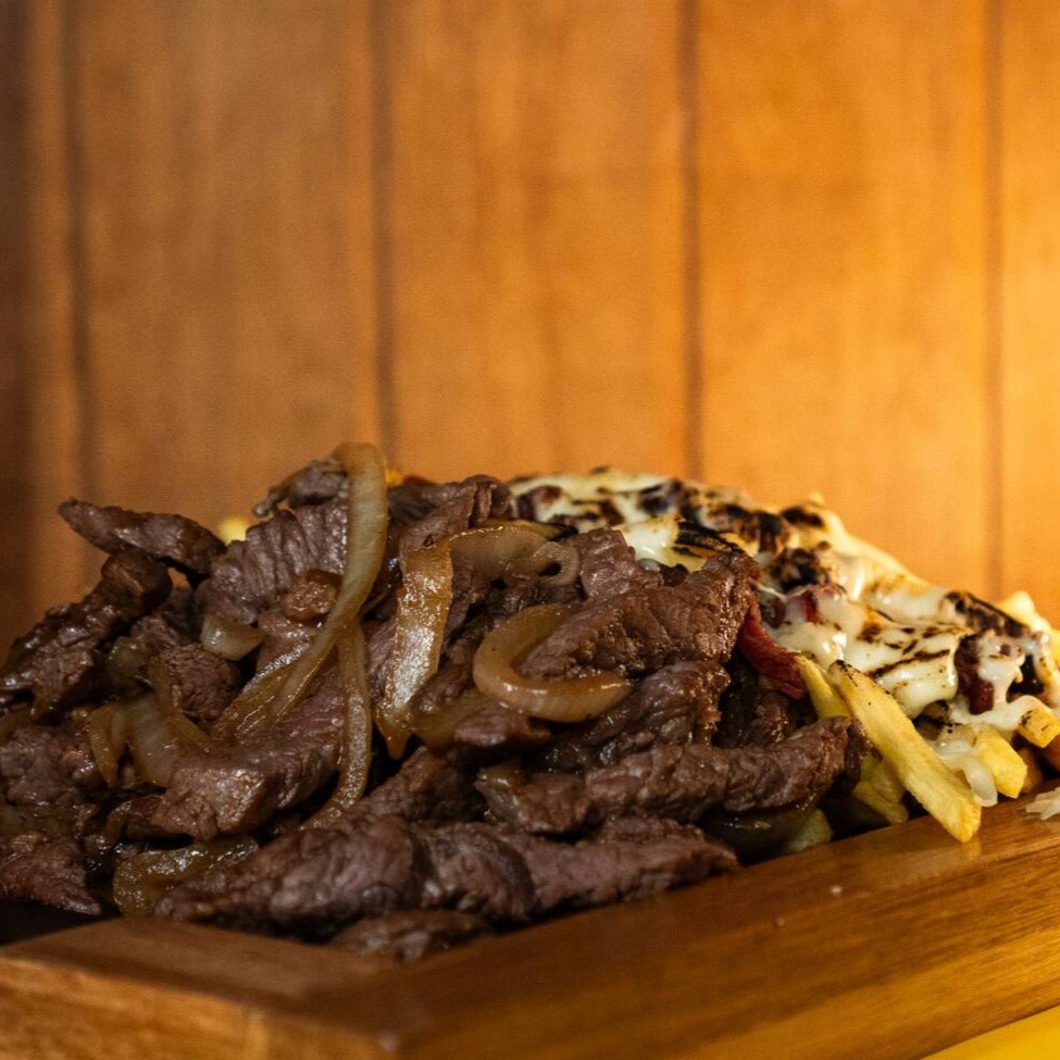 Desfrute de uma generosa porção de 500 gramas de saboroso coração de alcatra, meticulosamente preparado e acebolado para realçar seu paladar. Acompanha-se 500 gramas de fritas fininhas com corte de 7 milímetros, cuidadosamente cobertas com queijo derretido e pedaços de bacon crocante para uma experiência gastronômica inigualável.