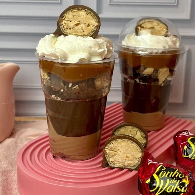 O copo é composto por um mousse de chocolate, brigadeiro de chocolate ao leite, Brownie juntamente com pedaços crocantes de Sonho de Valsa, Doce de Leite, finalizado com chantininho e Sonho de Valsa.