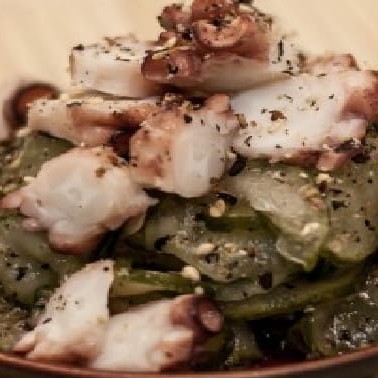 Salada de pepino marinada com polvo finalizada com gergelim.