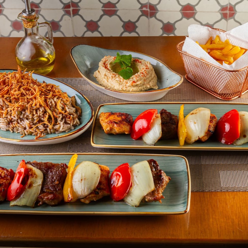 2 Espetos árabes mistos + pasta de alho ou Hommus + Arroz com lentilha e cebola crocante + batata fritas