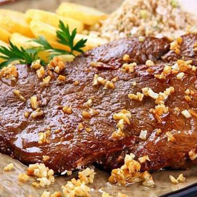 Apresentamos o majestoso 'Bife ao Oswaldo Aranha', uma das estrelas da categoria 'Chef Barros apresenta: Carnes'. Este prato, repleto de sabor e tradição, apresenta um suculento bife, preparado com maestria, ressaltando a textura macia e o sabor inigualável da carne. Cada garfada é um convite para uma experiência culinária inesquecível. Experimente e encante-se com essa maravilha da nossa cozinha. Não perca a oportunidade de saborear essa delícia!