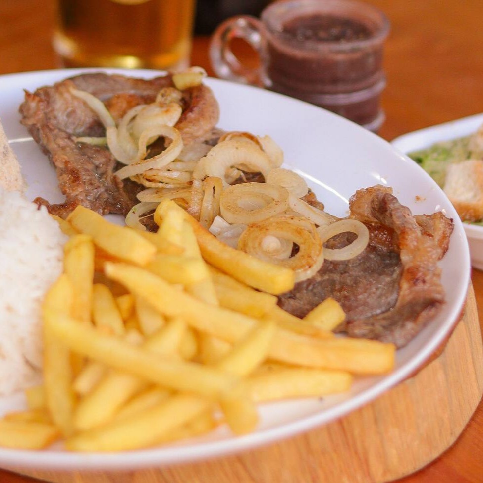 Marmita executiva acompanha: arroz branco, feijão preto, farofa, batata frita e salada de alface com tomate e cebola.