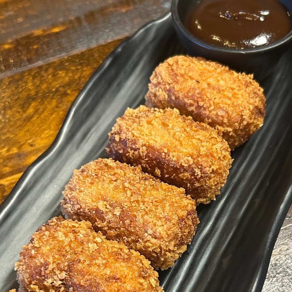 Croquete sem massa, feito com copa lombo defumado na casa, Catupiry, mozarela e empanado na farinha panko. Acompanha molho barbecue com bourbon e mel. (5 unidades)