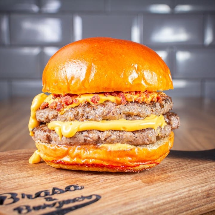 A Cremosidade do super cheddar em dose dupla.  Pão de brioche 2 carnes de 160g Creme de cheddar da casa Farofa de bacon crocante