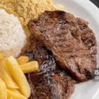 O filé mignon grelhado é acompanhado de arroz, feijão, farofa de ovos e batata frita.