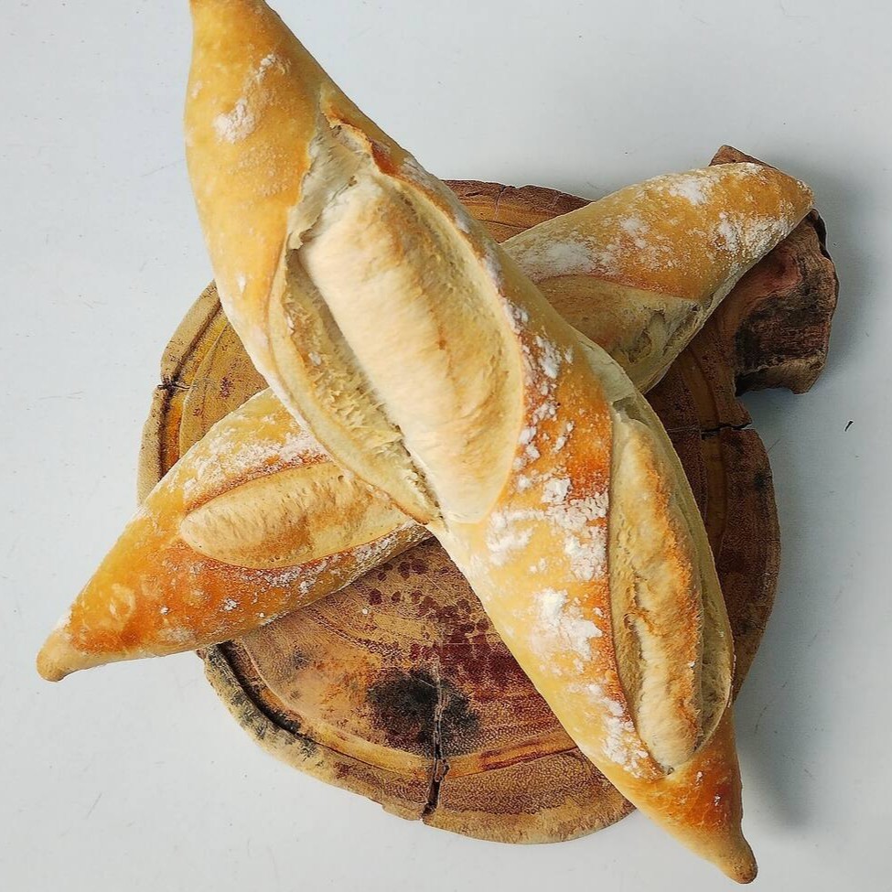 Nossa Baguete Parisiense é um pão artesanal de fermentação longa, que se destaca pelo seu processo meticuloso de preparo. Seu sabor é único, exalando a doçura suave do trigo e os aromas terrosos da fermentação lenta. Este é um pão perfeito para um simples café da manhã ou como acompanhamento para sopas e queijos. Experimente e aprecie cada mordida dessa verdadeira obra-prima da panificação.