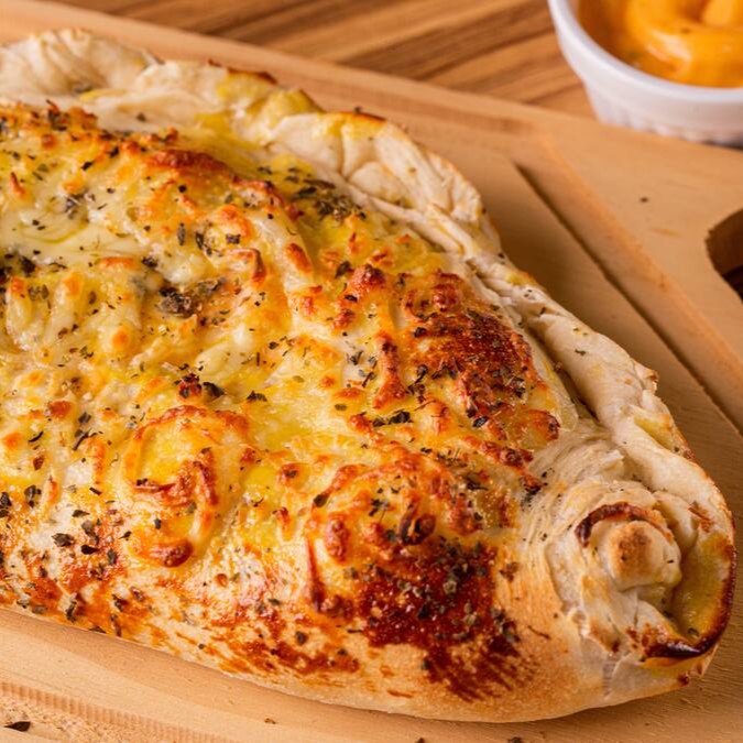 Molho, muçarela, calabresa em fatias, requeijão cremoso, ovos cozidos e orégano