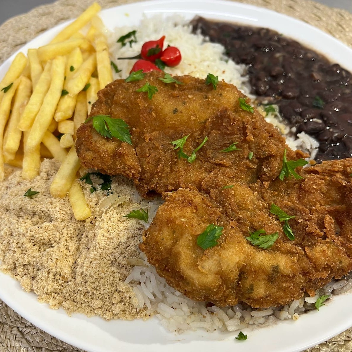 Frango empanado com casquinha crocante e tempero de mãe. Servido com arroz, feijão, farofa caprichada e batata frita bem douradinha com 1 Guaracamp geladinho.