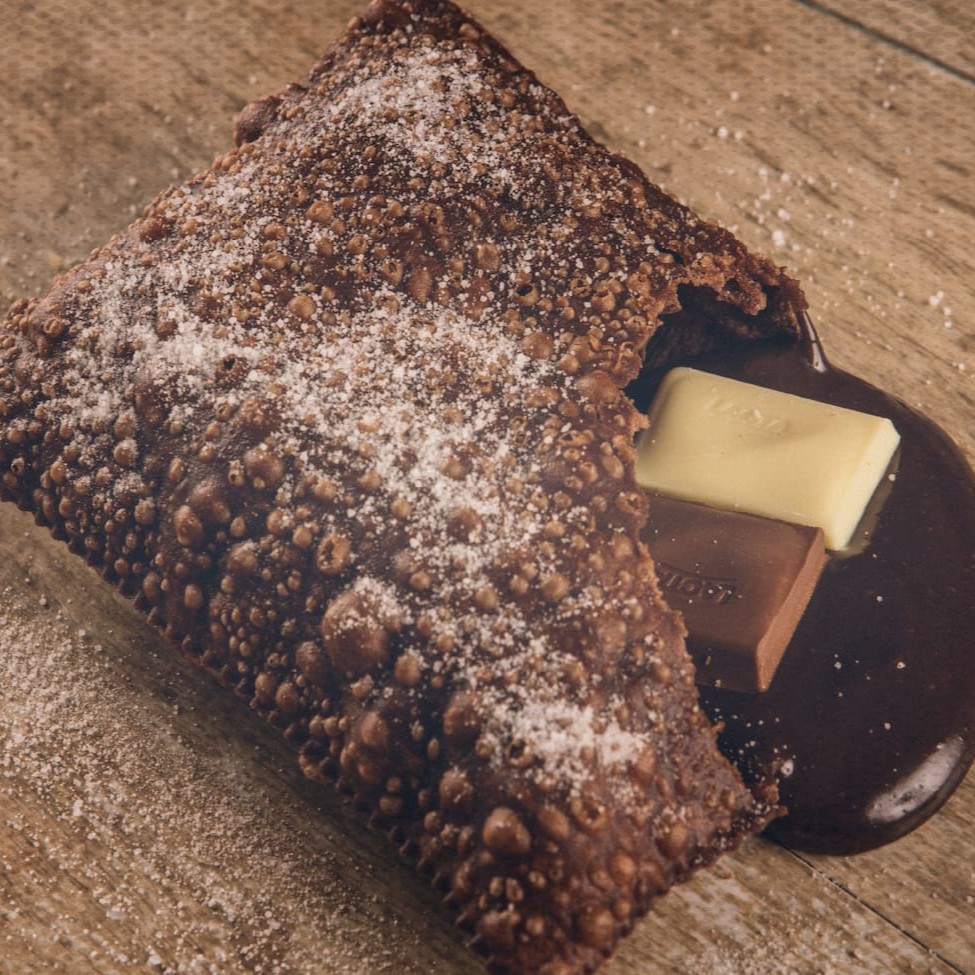 Delicioso pastel crocante recheado de chocolate branco e chocolate preto, combinação espetacular! (Tamanho 14 x 9,5cm)