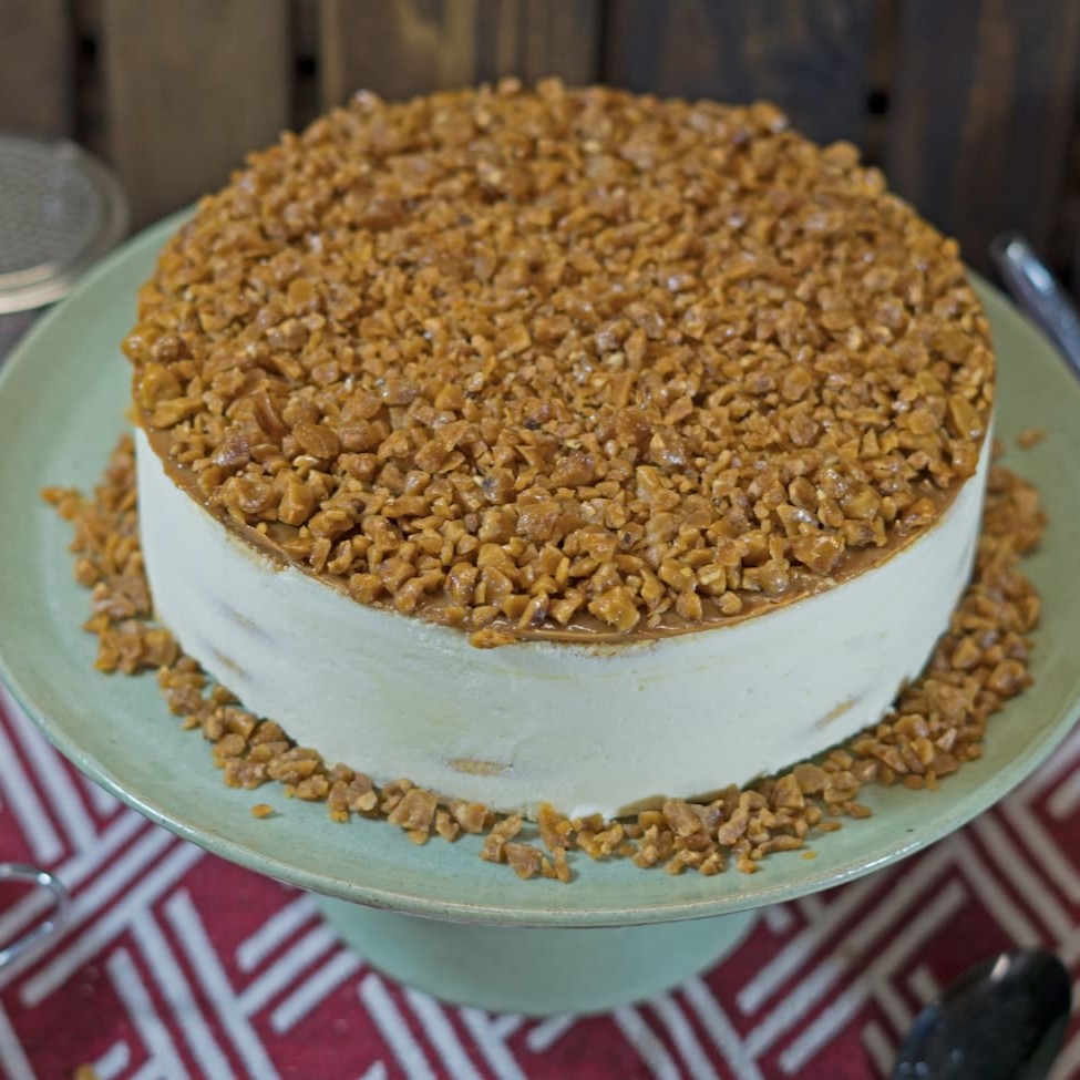 Creme de baunilha intercalado com biscoito maria e recheado de doce de leite com crocantes de pé de moleque.   Diâmetro de 18 cm servindo aprox. 12 fatias.